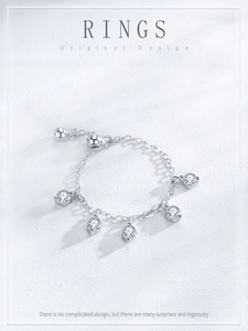 Macro shot of an adjustable silver chain ring featuring five sparkling round zirconia charms