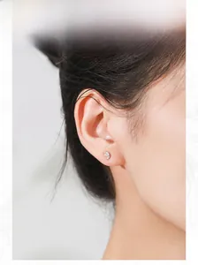 Detail of S925 sterling silver leaf stud earring with cubic zirconia on model