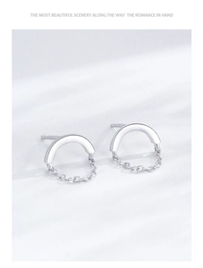 Macro shot of S925 sterling silver chain link hoop earrings on white silk fabric
