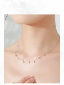 Close-up of elegant S925 sterling silver necklace with sparkling zirconia charms on a model