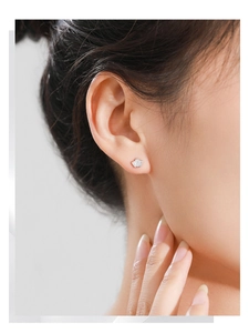 Gros plan sur boucle d'oreille couronne en argent S925 avec diamants baguette sur l'oreille