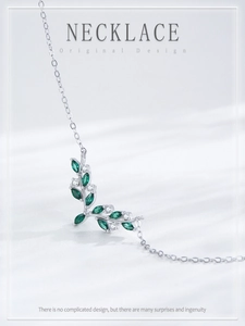 Detailed macro view of S925 silver necklace featuring green marquise-cut leaves