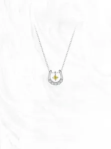 Détail du pendentif fer à cheval en argent S925 avec zircon jaune sur fond de marbre