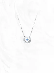 Macro detail of S925 sterling silver horseshoe pendant with blue zircon stone and pavé gems