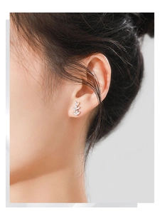 Detailed view of silver leaf stud earrings with zircon stones worn on the ear model