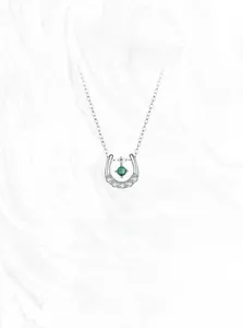 Detail of horseshoe U-shaped silver necklace with green gem and pavé diamonds