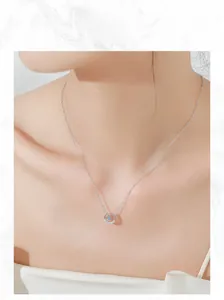 Close-up of S925 silver horseshoe necklace with sparkling blue zircon on model's neck