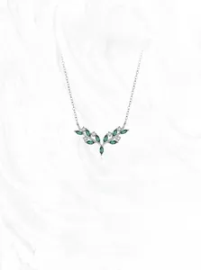 Detail of silver olive branch necklace featuring green marquise gemstones and white zircons