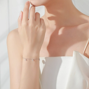 Elegant S925 silver bracelet with three zircon pendants on a model's wrist with soft light