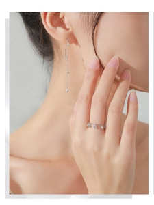 Detail of adjustable S925 silver chain ring with zircon charms on a model's finger