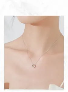 Gros plan du collier pendentif fer à cheval avec zircon jaune sur le décolleté