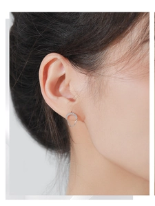 Gros plan sur des boucles d'oreilles chaînettes en argent S925 avec zircons incrustés