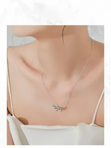 Close-up of S925 silver necklace with green olive branch leaf pendant on model neck
