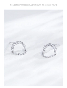 Détail macro de boucles d'oreilles en argent S925 avec zircons et fine chaîne pendante