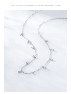 Macro shot of S925 sterling silver chain with zircon charms and subtle window shadow