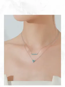 Close-up of double-layer S925 silver necklace with turquoise bar and triangle pendants