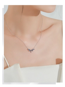 Detail of S925 sterling silver necklace with blue marquise leaf pendant on female neck