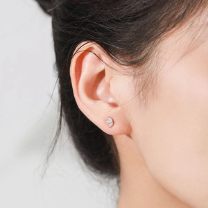 Asymmetric S925 sterling silver leaf studs with zircons worn on model ear