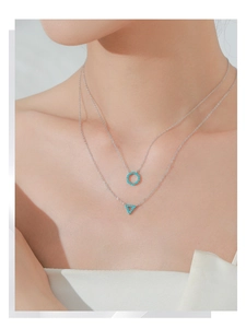 Detail of S925 silver double layer necklace with turquoise circle and triangle pendants