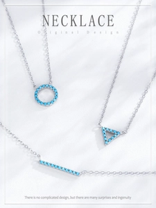 Macro detail of geometric silver necklaces with inset turquoise stones on white background