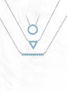 Detailed view of geometric 925 silver necklaces with turquoise pendants on marble background