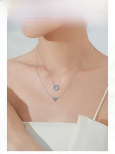 Close-up of double-layer S925 silver necklace with blue stone geometric pendants on model