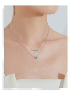 Detail shot of a double-layered S925 silver necklace with turquoise geometric pendants