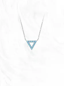 Close-up of S925 sterling silver triangle pendant with turquoise stones on marble