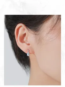 Gros plan d'un mannequin portant des boucles d'oreilles goutte en argent et pierre de lune