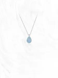 Macro detail of S925 sterling silver teardrop turquoise pendant with blue gemstones
