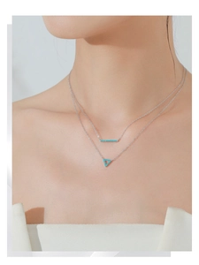 Close-up of a double layer S925 silver necklace with turquoise hollow triangle pendant