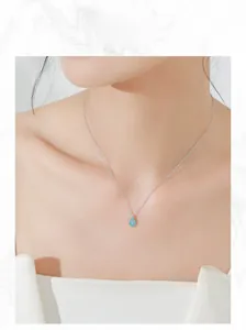 Close-up of a silver waterdrop turquoise pendant necklace on a female model's neck