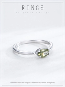 Detailed macro view of an oval olive green gemstone on a slim S925 silver ring