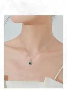 Détail du collier émeraude carré avec diamants porté par un mannequin
