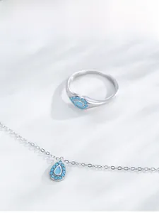 Detailed view of silver jewelry set with teardrop turquoise pendant and matching ring