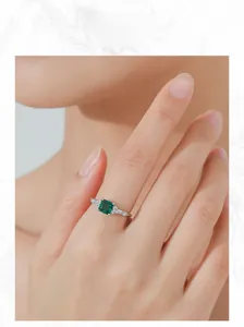 Close-up of elegant S925 silver ring featuring a square emerald gemstone on model's hand