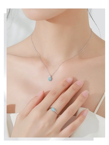Detail of S925 sterling silver waterdrop turquoise pendant necklace and matching ring on model
