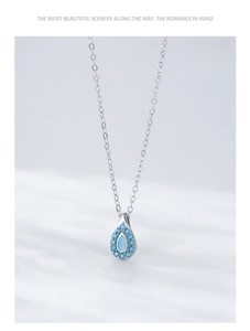 Macro detail of S925 sterling silver water drop necklace with turquoise stone and blue accents