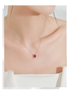 Gros plan d'un collier en argent S925 avec pendentif grenade et zircons sur un mannequin