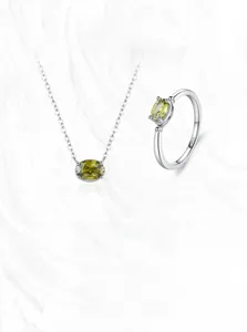 Détail d'un ensemble de bijoux en argent S925 avec pierres ovales vert olive sur marbre