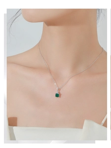 Primo piano della collana in argento S925 con pendente quadrato verde smeraldo sulla clavicola