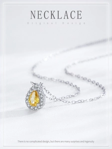 Macro shot of S925 silver necklace with pear-cut yellow gemstone and zircon details