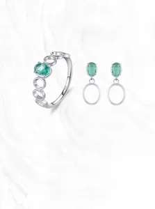 Macro detail of S925 sterling silver ring and earrings with oval green gemstones