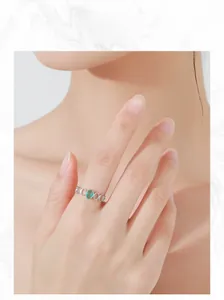 Close-up of S925 silver ring with oval green gemstone and hollow band on hand