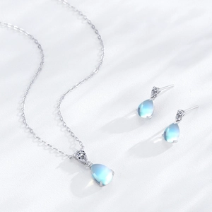Elegantes 925 Silber Schmuckset mit Mondstein-Anhänger und Ohrringen auf Seidenstoff