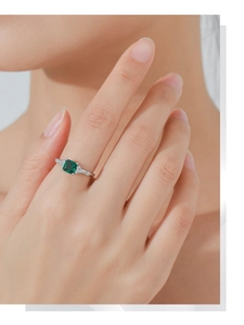 Dettaglio anello in argento S925 con smeraldo verde rettangolare e diamanti laterali lucidi