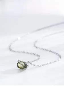 Vue macro d'un collier en argent S925 avec un pendentif ovale en pierre vert olive