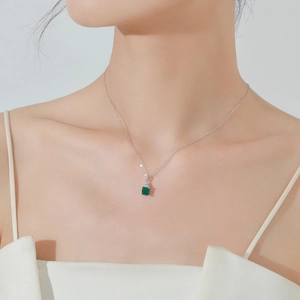 Élégant collier en argent S925 avec pierre verte taille émeraude porté par un modèle
