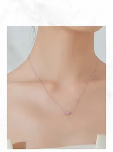 Primo piano della collana in argento S925 con gemma rosa ovale indossata da modella