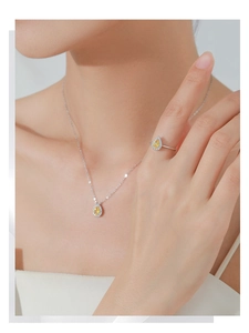 Macro shot of S925 silver necklace and ring set with pear cut yellow stones and diamonds